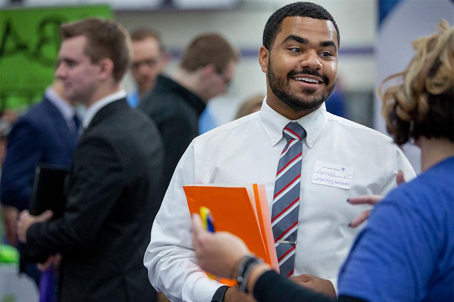 Business student talks to a professor on the University of Wisconsin Whitewater campus.