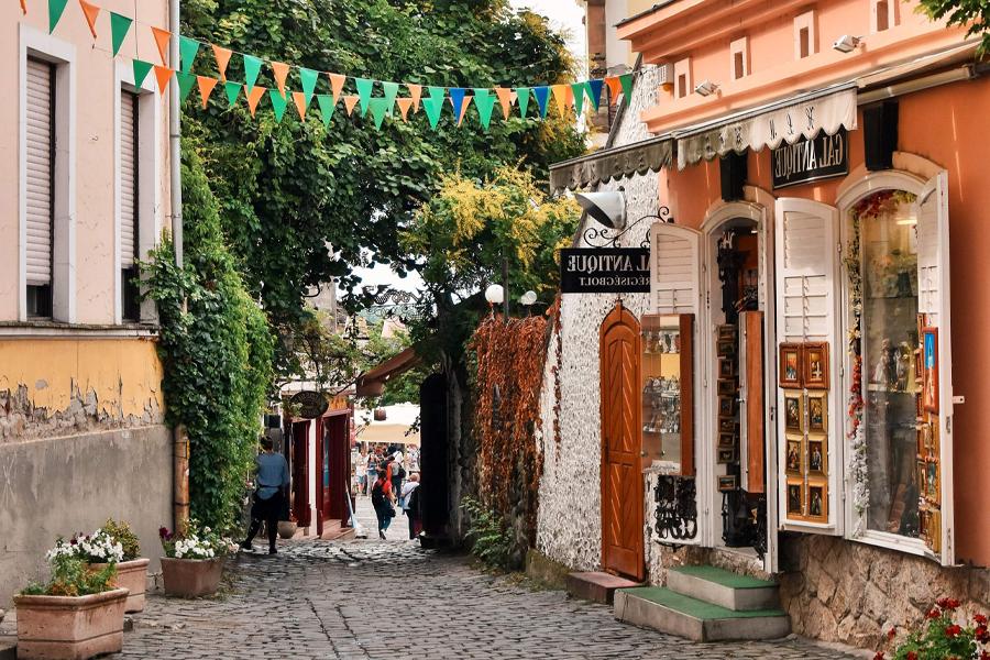 A cobblestone walkway in France between two buildings.