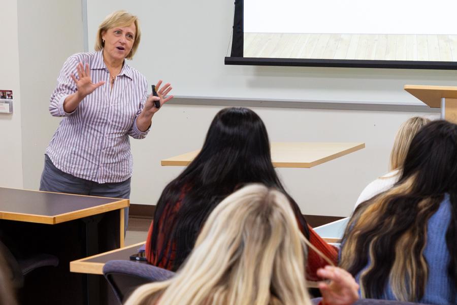 A faculty member speaks at the front of class.