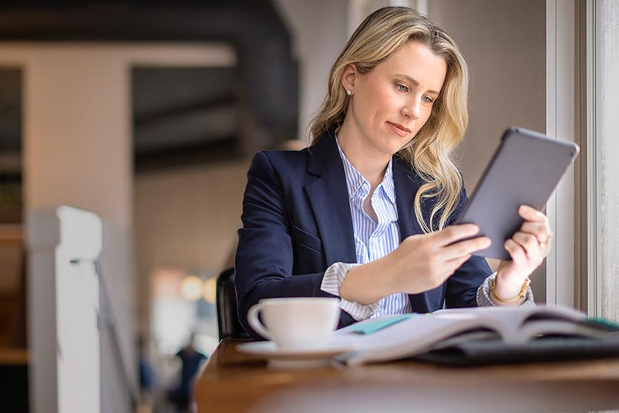 Woman studying with tablet by cafe window