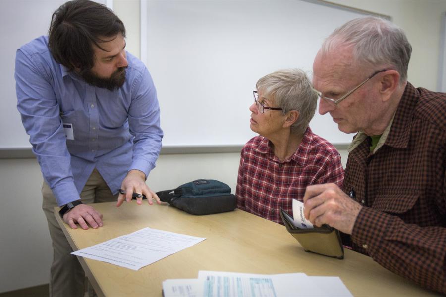 A person helps a couple with their taxes.